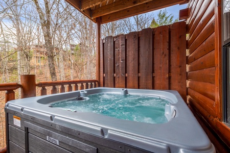 Hot tub on covered deck at Family Ties Lodge, a 4 bedroom cabin rental located in pigeon forge