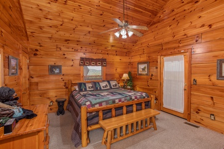 Bedroom with a log bed, bench, and vaulted ceiling at Bear Country, a 3-bedroom cabin rental located in Pigeon Forge