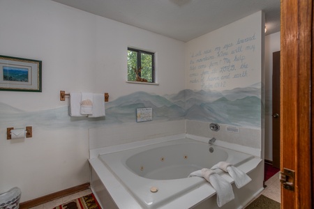 Custom mountain mural behind a jacuzzi at Black Bear Ridge, a 3-bedroom cabin rental located in Pigeon Forge