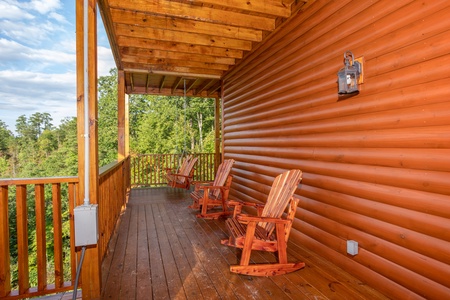 Deck rockers in a row on a covered porch at Four Seasons Palace, a 5-bedroom cabin rental located in Pigeon Forge