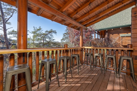 Bar stools and bar top on a covered deck at Loving Every Minute, a 5 bedroom cabin rental located in Pigeon Forge