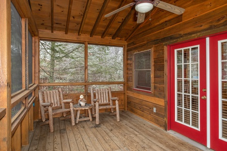 Two chairs on the screened in porch at Alpine Romance, a 2 bedroom cabin rental located in Pigeon Forge