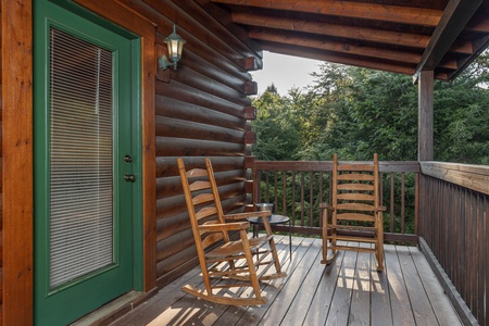 Rocking chairs on a covered deck at Family Getaway, a 4 bedroom cabin rental located in Pigeon Forge