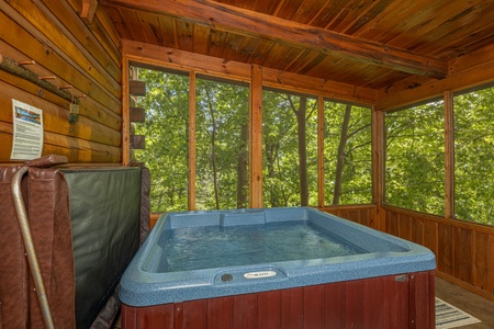 Hot tub on a screened porch at Moonlit Pines, a 2 bedroom cabin rental located in Pigeon Forge