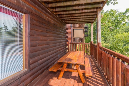 Picnic table on a covered deck at A Beautiful Memory, a 4 bedroom cabin rental located in Pigeon Forge
