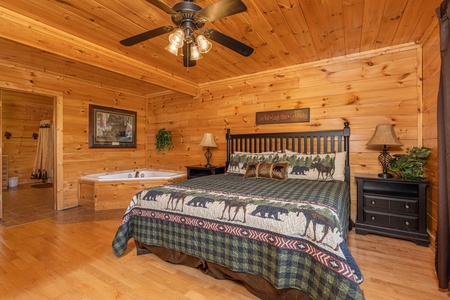 Bedroom with a king bed, night stands, lamps, and jacuzzi at Bears Don't Bluff, a 3 bedroom cabin rental located in Pigeon Forge