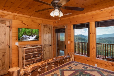 Bedroom with a TV, dresser, deck access, and mountain views at Four Seasons Palace, a 5-bedroom cabin rental located in Pigeon Forge