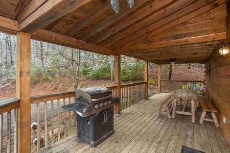 Propane grill and picnic table on a covered deck at Alpine Romance, a 2 bedroom cabin rental located in Pigeon Forge