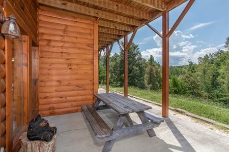 Picnic table on a patio below the deck at Cabin Fever, a 4-bedroom cabin rental located in Pigeon Forge