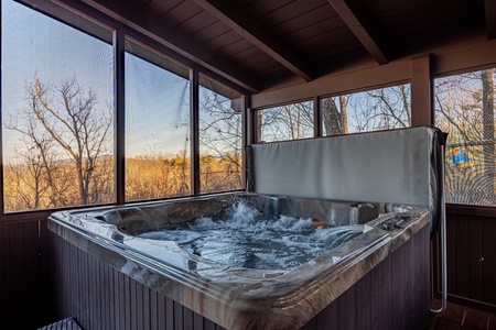 Hot tub on screened-in porch at Gone To Therapy, a 2 bedroom cabin rental located in Gatlinburg