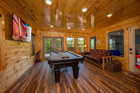 Pool table, flat screen, and futon at Make A Splash, a 2 bedroom cabin rental located in gatlinburg