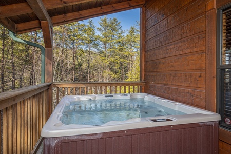 Hot tub on a covered deck at King of the Mountain, a 3 bedroom cabin rental located in Pigeon Forge