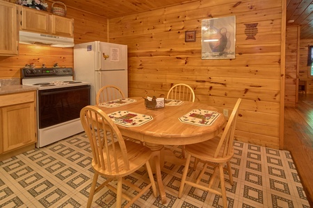 Dining space with seating for four in a kitchen with white appliances at Dream Catcher, a 1-bedroom cabin rental located in Pigeon Forge