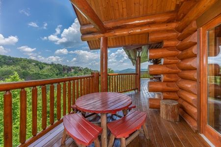 Dining space for four on the deck at God's Country, a 4 bedroom cabin rental located in Pigeon Forge