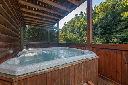 Hot tub with privacy fence on a covered deck at Family Getaway, a 4 bedroom cabin rental located in Pigeon Forge