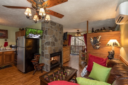 TV, foosball coffee table, and fireplace in the living room at Bear Mountain Hollow, a 1 bedroom cabin rental located in Pigeon Forge