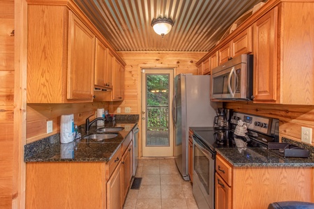 Galley kitchen with stainless appliances at License to Chill, a 3 bedroom cabin rental located in Gatlinburg