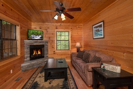 Family room with fireplace, tv, ceiling fan, and seating at Family Ties Lodge