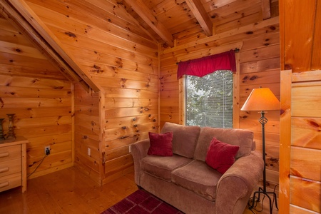 Loveseat in a bedroom at A Beautiful Memory, a 4 bedroom cabin rental located in Pigeon Forge