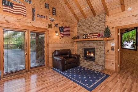 Fireplace and chair in the game room at Patriot Pointe, a 5 bedroom cabin rental located in Pigeon Forge
