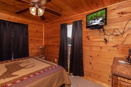 Bedroom with a dresser and wall mounted television at Cabin Fever, a 4-bedroom cabin rental located in Pigeon Forge
