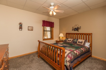 Bedroom with a bed, night stand, and dresser at Stones Throw, a 4 bedroom cabin rental located in Pigeon Forge