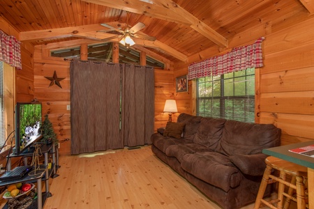 living room with couch and television at angel's dream a 1 bedroom cabin rental located in gatlinburg