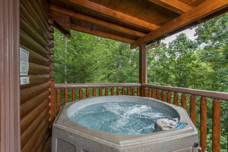 Hot tub on a covered deck at Laid Back, a 2 bedroom cabin rental located in Pigeon Forge