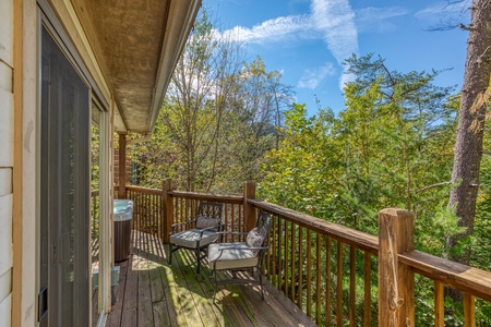 Chairs on a deck with wooded views at Into the Woods, a 3 bedroom cabin rental located in Pigeon Forge