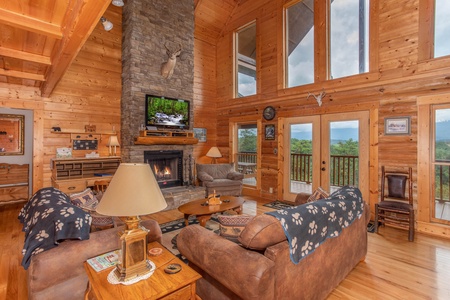 Living room with fireplace, TV, and large windows for lots of light at I Do Love Views, a 3 bedroom cabin rental located in Pigeon Forge