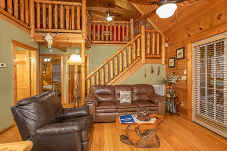 Living room with a large chair and sofa at Alpine Romance, a 2 bedroom cabin rental located in Pigeon Forge