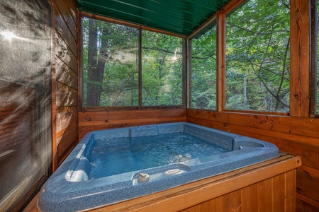 Hot tub on a screened in porch at Firefly Ridge, a 2 bedroom cabin rental located in Pigeon Forge