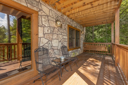 Lower deck seating and swing at Cub's Crossing, a 3 bedroom cabin rental located in Gatlinburg
