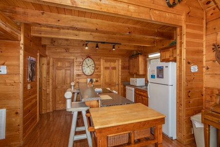 Kitchen with white appliances and breakfast bar at Mountain Music, a 5 bedroom cabin rental located in Pigeon Forge