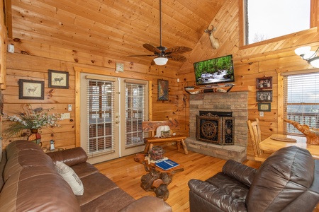 Living room with vaulted ceiling, fireplace, and TV at Alpine Romance, a 2 bedroom cabin rental located in Pigeon Forge
