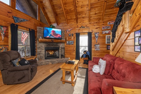 Living room with fireplace and TV at Nascar Nation, a 2 bedroom cabin rental located in Pigeon Forge