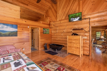 King bedroom with sleeping oft, soaker tub, and TV at Great View Lodge, a 5-bedroom cabin rental located in Pigeon Forge