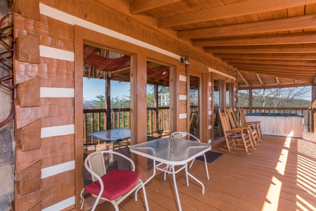 Dining table for two and rocking chairs on the deck at Mountain Glory, a 1 bedroom cabin rental located in Pigeon Forge