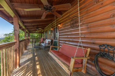 Swing and furniture on a covered porch at Grand View, a 3 bedroom cabin rental located in Sevierville