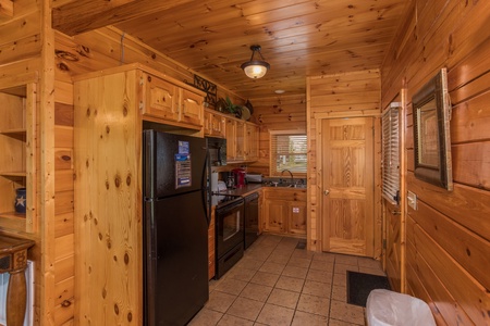 Kitchen with black appliances at Howlin' in the Smokies, a 2 bedroom cabin rental located in Pigeon Forge