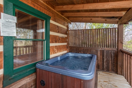 Hot tub with privacy fence on a covered deck at Blue Mountain Views, a 1 bedroom cabin rental located in Pigeon Forge
