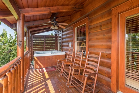 Deck with a hot tub and rocking chairs at Graceland, a 4-bedroom cabin rental located in Pigeon Forge