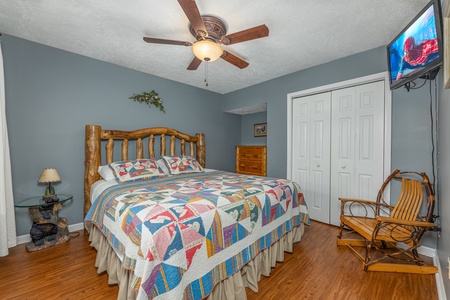 Bedroom with a night stand, chair, and TV at Wildlife Retreat, a 3 bedroom cabin rental located in Pigeon Forge