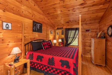 King-sized four-post bed in the upper bedroom at Hibernation Station, a 3-bedroom cabin rental located in Pigeon Forge