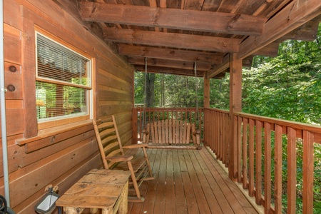 Swing and rocking chair on a covered porch at Misty Mountain Escape, a 2 bedroom cabin rental located in Gatlinburg
