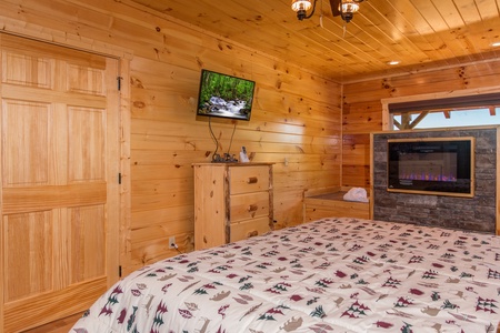 Dresser, TV, and fireplace in a bedroom at Canyon Camp Falls, a 2 bedroom cabin rental located in Pigeon Forge