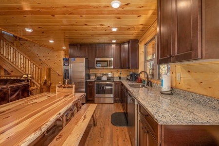 Kitchen with stainless appliances, granite counters, and dining space at Pinot Splash, a 4 bedroom cabin rental located in Gatlinburg