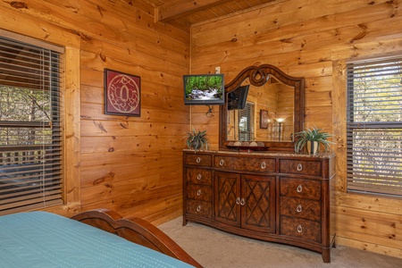 Dresser with mirror and a TV in a bedroom at King of the Mountain, a 3 bedroom cabin rental located in Pigeon Forge