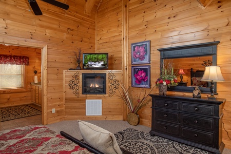 Fireplace, TV, dresser, and en suite bath in the loft bedroom at Better View, a 4 bedroom cabin rental located in Pigeon Forge