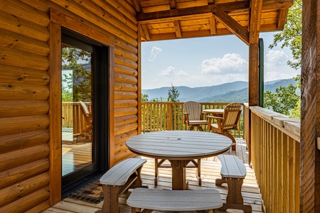 Deck dining table and bench seats at J's Hideaway, a 4 bedroom cabin rental located in Pigeon Forge